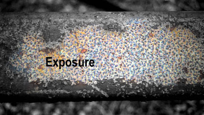 Exposure, still: *Exposure* title card: This image is of an orange/brown rust-covered steel beam. In Photoshop I removed the colour from the central zone of the image and overlaid the titles and credit text. (Also see credit cards below).